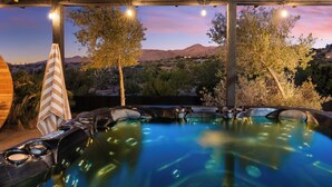 An outdoor hot tub area with a view of mountains and trees at dusk. - Desert Dreams: private pool, sauna, cold plunge, star dome, gym and theatre (Yucca Valley)