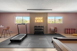 A gym with treadmills, dumbbells, and a neon sign stating 'MOVEMENT IS MEDICINE.' - Desert Dreams: private pool, sauna, cold plunge, star dome, gym and theatre (Yucca Valley)