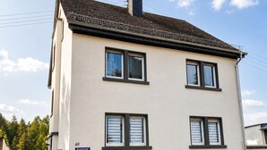 A two-story building with a flat roof, multiple windows, and a small entrance with steps. - Modern Vacation Rental in Idar-Oberstein (Algenrodt) (Idar-Oberstein)