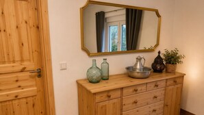 A wooden cabinet with drawers, a mirror, and decorative items. - Modern Vacation Rental in Idar-Oberstein (Algenrodt) (Idar-Oberstein)