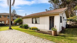 A single-story house with a tiled roof, a front door, and a small porch area. - The Beach Bach - Pet Friendly with Firepit (Culburra Beach)