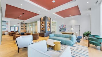 A spacious lobby with a high ceiling, modern furniture, and a central seating area.