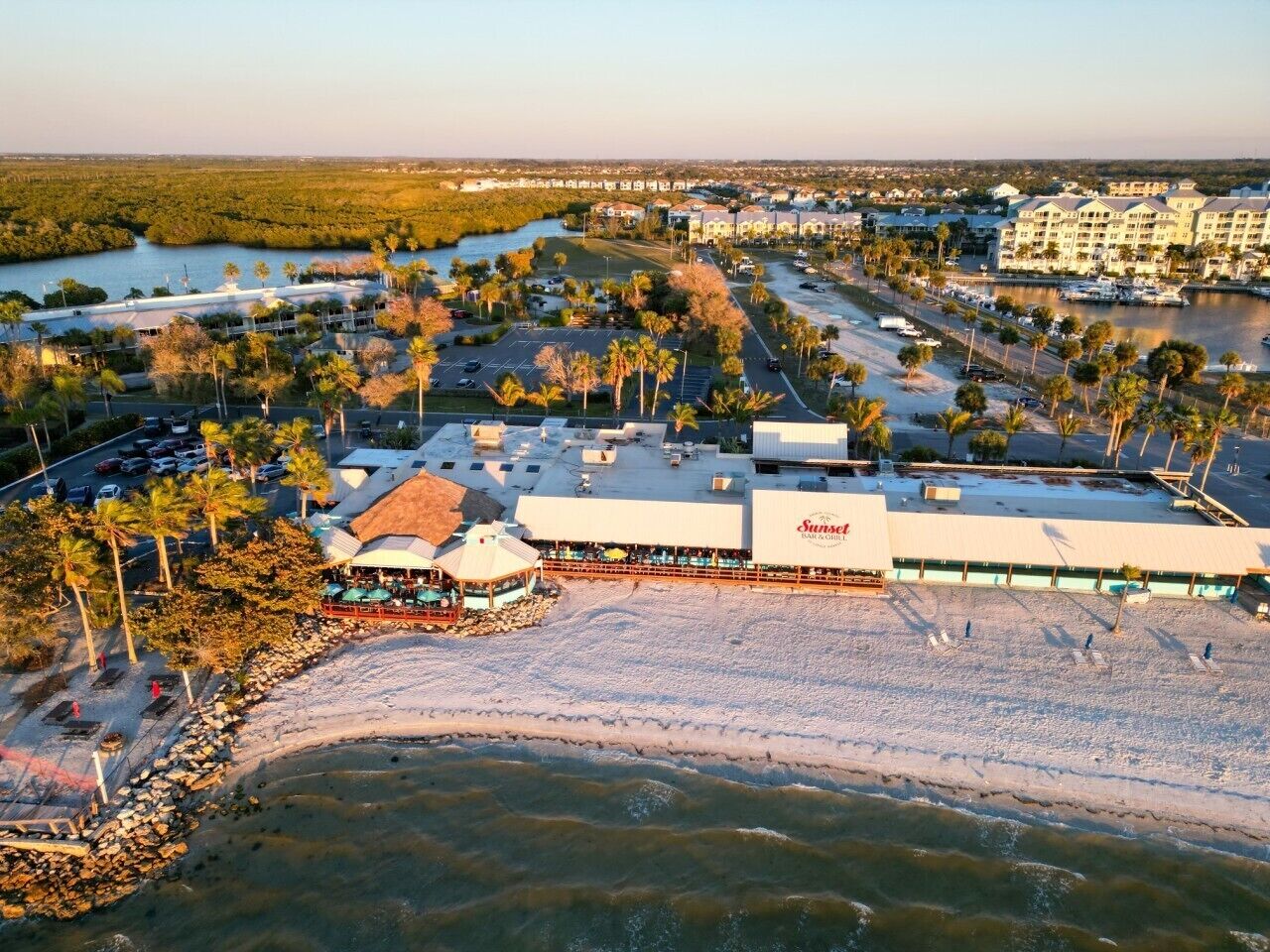 Un hotel frente al mar con playa, piscina y restaurante.