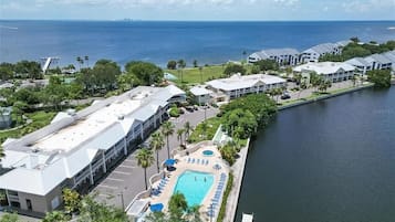 Un resort con piscina, vistas al agua y edificios modernos.