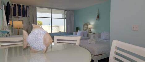 Una habitación de hotel con una mesa redonda, dos camas, una ventana con cortinas y un adorno en la pared.