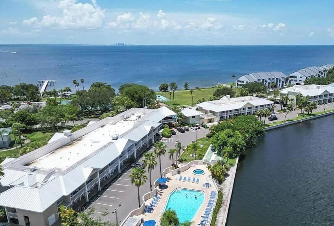Un resort con piscina, estacionamiento y vista al océano.