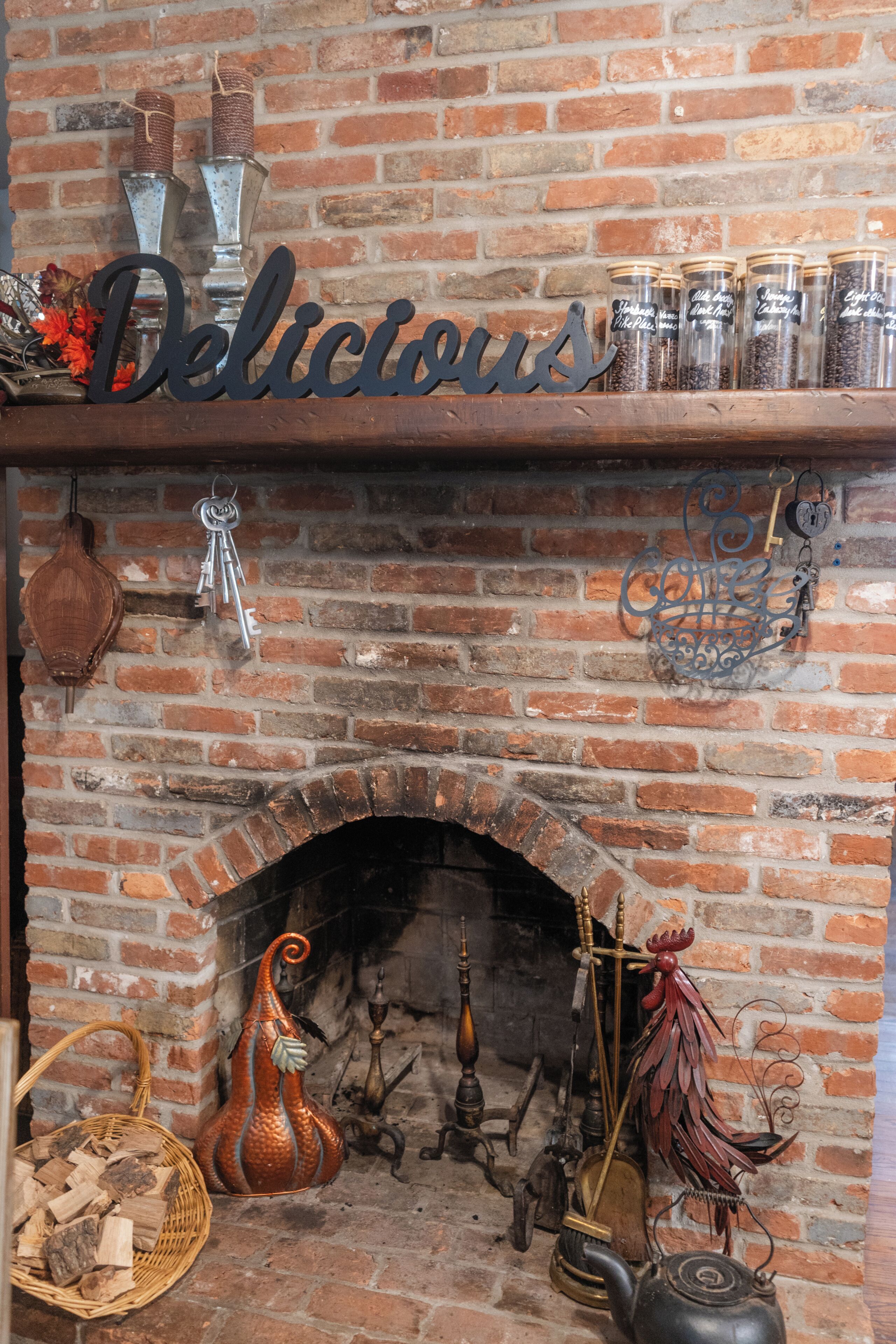 A brick fireplace with a decorative sign above it, a metal keychain, and various items like a basket and a decorative bird.