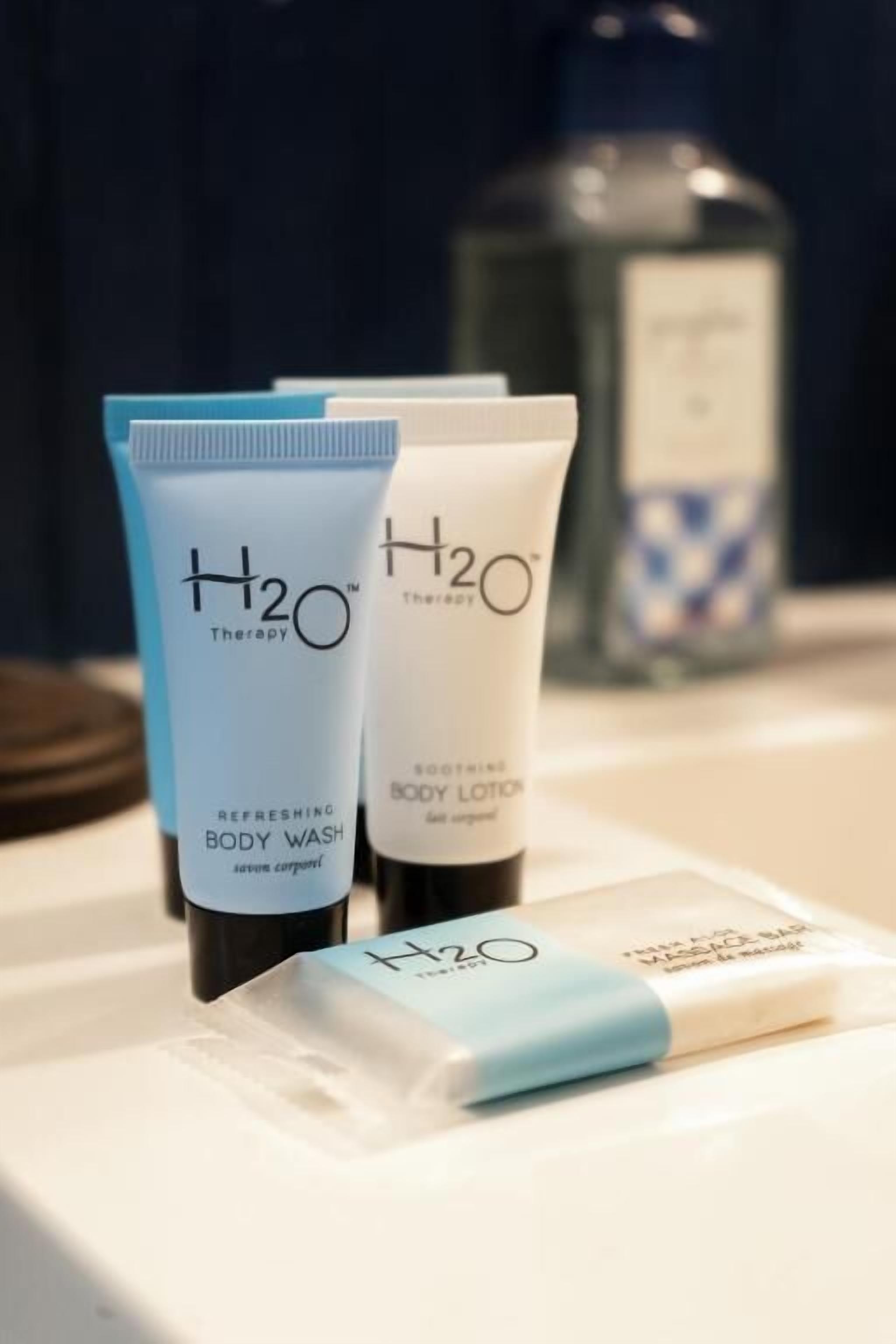 Three H2O Therapy products: a refreshing body wash, a soothing body lotion, and a body wash sachet.