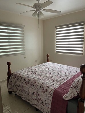 A bedroom with a bed, a ceiling fan, and two windows with blinds. - Casa Adriana. Comfort and safety. (El Sauzal)