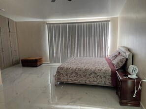 A bedroom with a bed, a bedside table with a fan, a wardrobe, and a bench. - Casa Adriana. Comfort and safety. (El Sauzal)