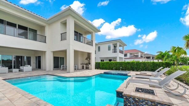 A modern two-story house with a swimming pool, outdoor seating, and a well-maintained garden. - Enormous 8 Bedroom Resort Home with View of 18th Hole near Disney with Resort &. (Kissimmee)