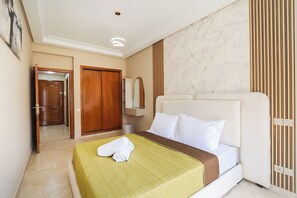Ein Hotelzimmer mit einem Bett, einem Holzschrank, einem Spiegel und einer Tür.