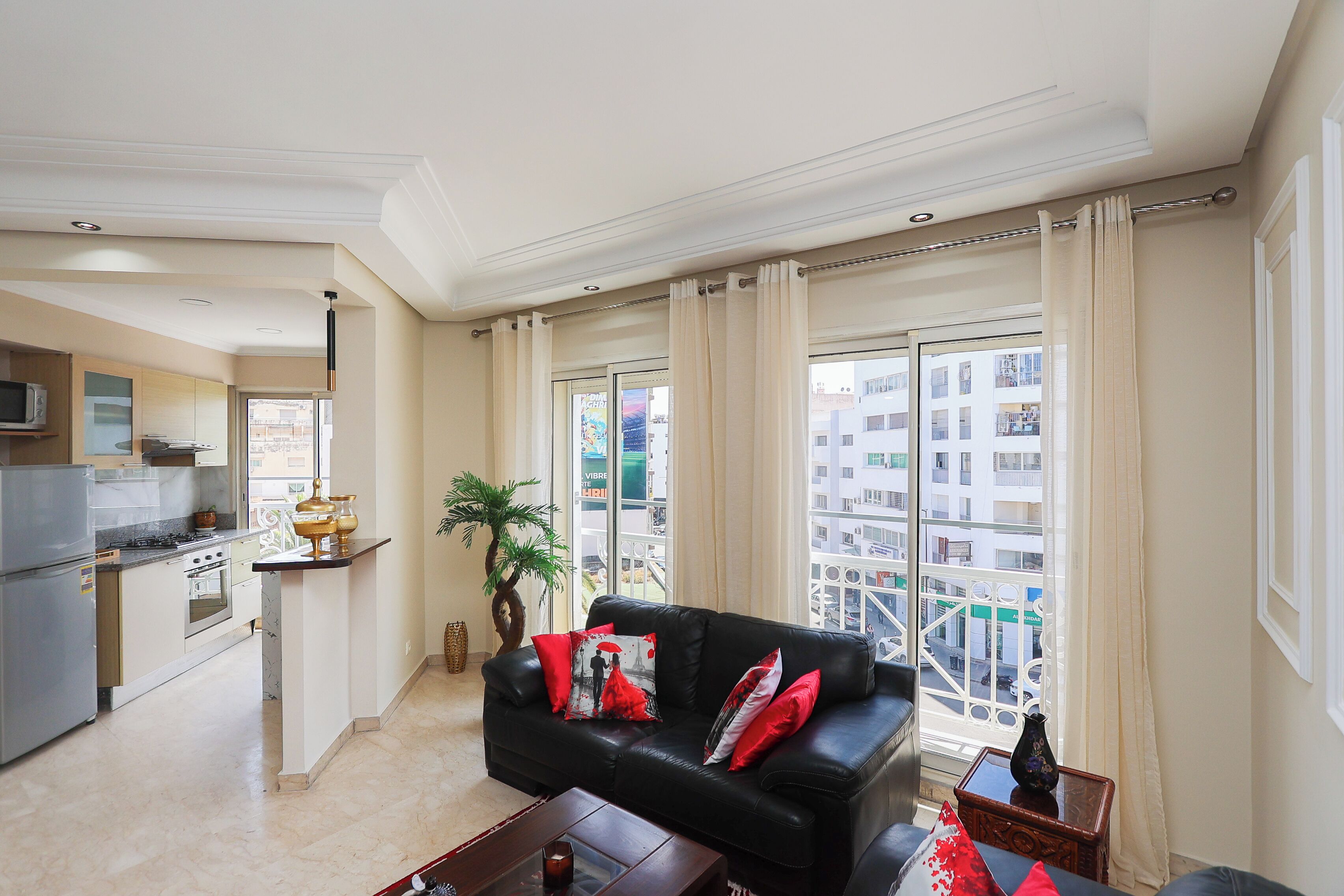 A modern apartment with a living room, kitchen, and large windows.