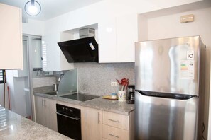 A modern kitchen with a stainless steel refrigerator, a built-in oven, and a microwave. - Newly Renovated 2BR Apartment in Lima (Lince)