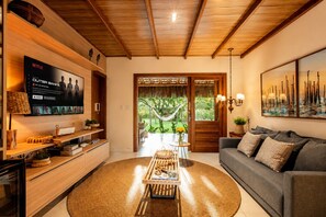 Ein Wohnzimmer mit Fernseher, einer Couch und Blick ins Freie.