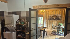 Uma sala de estar aconchegante com lareira, uma área de jantar com mesa e cadeiras, e vista para o exterior.