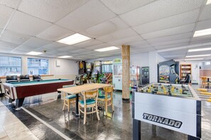 Un espace de loisirs équipé d’une table de billard, d’un baby-foot et de divers jeux électroniques.