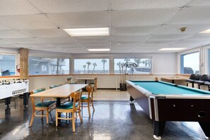 A room with a pool table, a foosball table, and a view of the beach. - Oceanview Studio, 2 Pools, Beach, Game Room, Patio (Daytona Beach)