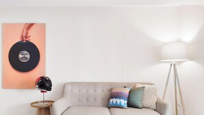 Ein Zimmer mit einer Couch, einer Lampe, einem Helm und einem Wandbild.