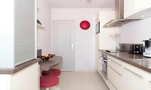 Eine kleine Küche mit Mikrowelle, Backofen und Kaffeemaschine.