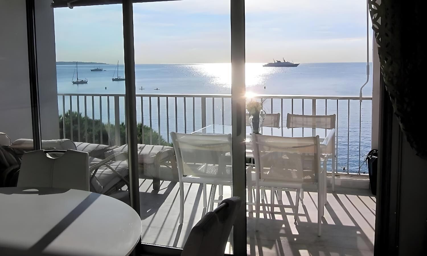 Ein Balkon mit Meerblick, einem Tisch und Stühlen.