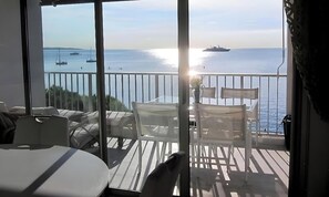 A balcony with a view of the sea, a table, and chairs. - BEACHFRONT APARTMENT IN THE PRESTIGIOUS PALM BEACH DISTRICT OF CANNES (Cannes)