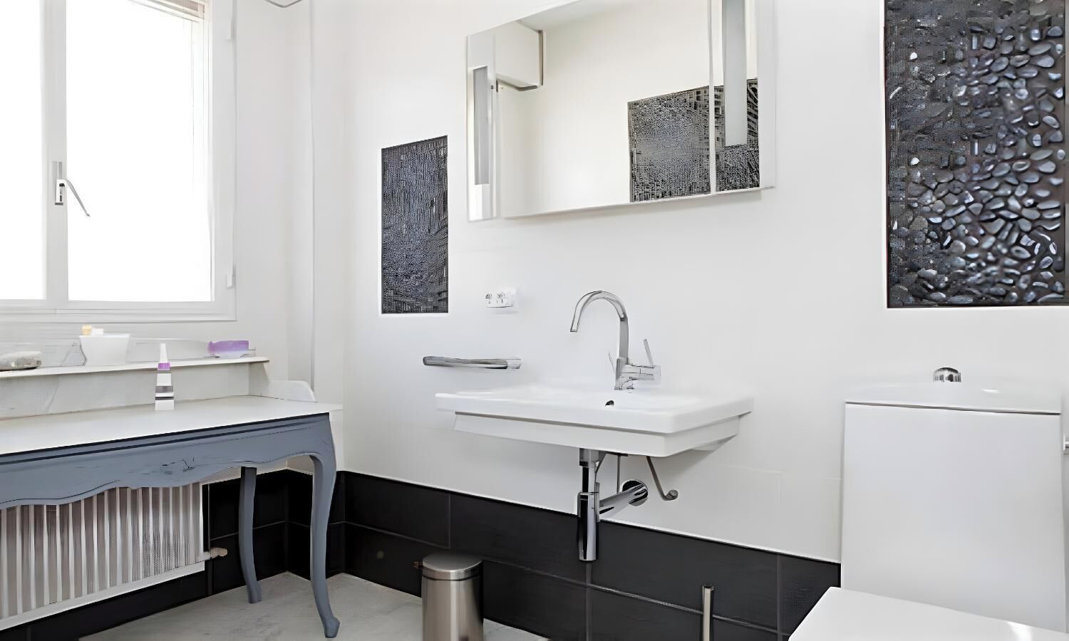Une salle de bain moderne avec un lavabo blanc, un miroir et un radiateur.