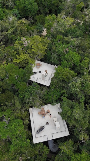 Two elevated outdoor areas with seating and a barbecue grill, surrounded by dense forest. - Tree60:· Jungle Villa Private Rooftop&Wood-Hot Tub (Chemuyil)