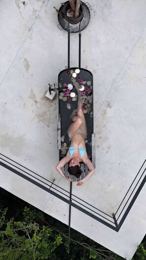 A person lying on a bench with a flower arrangement beside them. - Tree60:· Jungle Villa Private Rooftop&Wood-Hot Tub (Chemuyil)