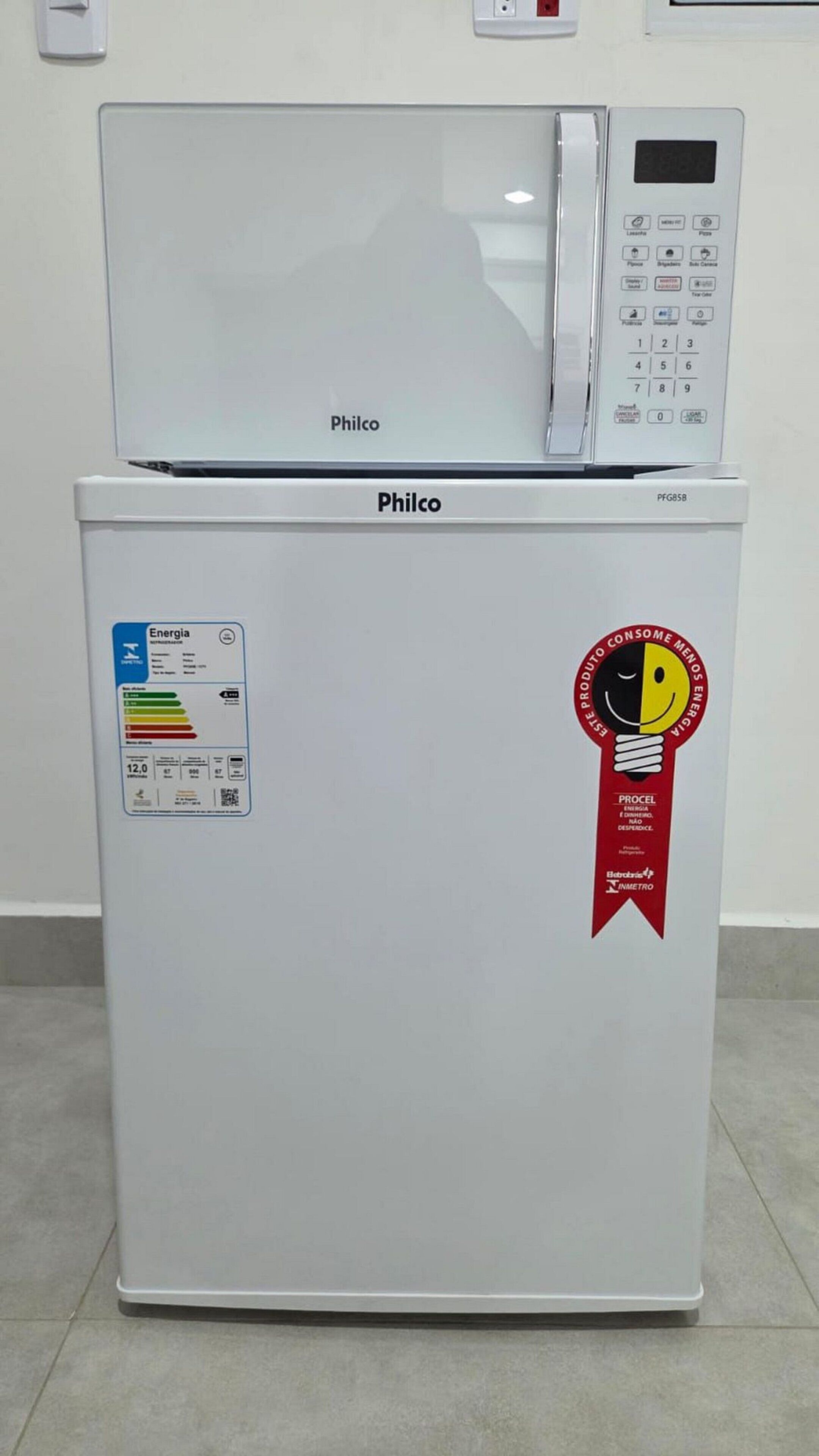 A white refrigerator with a microwave on top, labeled 'Philco,' and a sticker indicating energy efficiency.