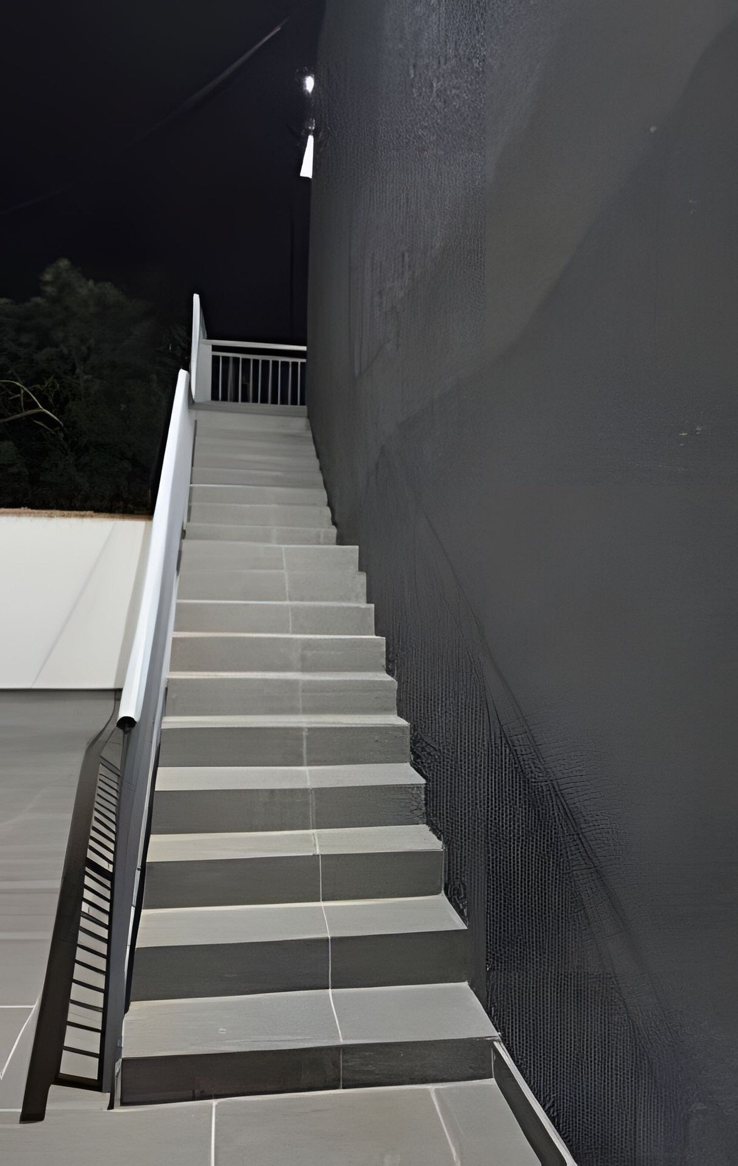 A set of outdoor stairs leading up to a balcony with a railing.