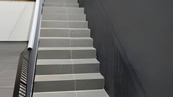 A set of outdoor stairs leading up to a balcony with a railing.