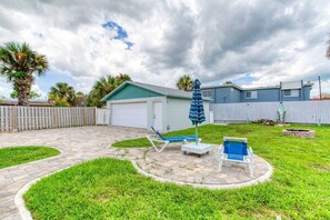 A backyard with a patio, two lounge chairs, a small shed, and a fenced area. - Pet-Friendly Daytona Beach Home Near the Beach (Daytona Beach)