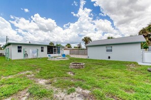 A residential area with two single-story houses, a grassy yard, and a small fire pit. - Pet-Friendly Daytona Beach Home Near the Beach (Daytona Beach)