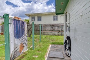 A residential property with a green exterior, a small front yard, and a visible water hose. - Pet-Friendly Daytona Beach Home Near the Beach (Daytona Beach)