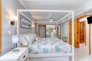 A bedroom with a four-poster bed, bedside lamps, a flat-screen TV, and a mirror. - Pet-Friendly Daytona Beach Home Near the Beach (Daytona Beach)