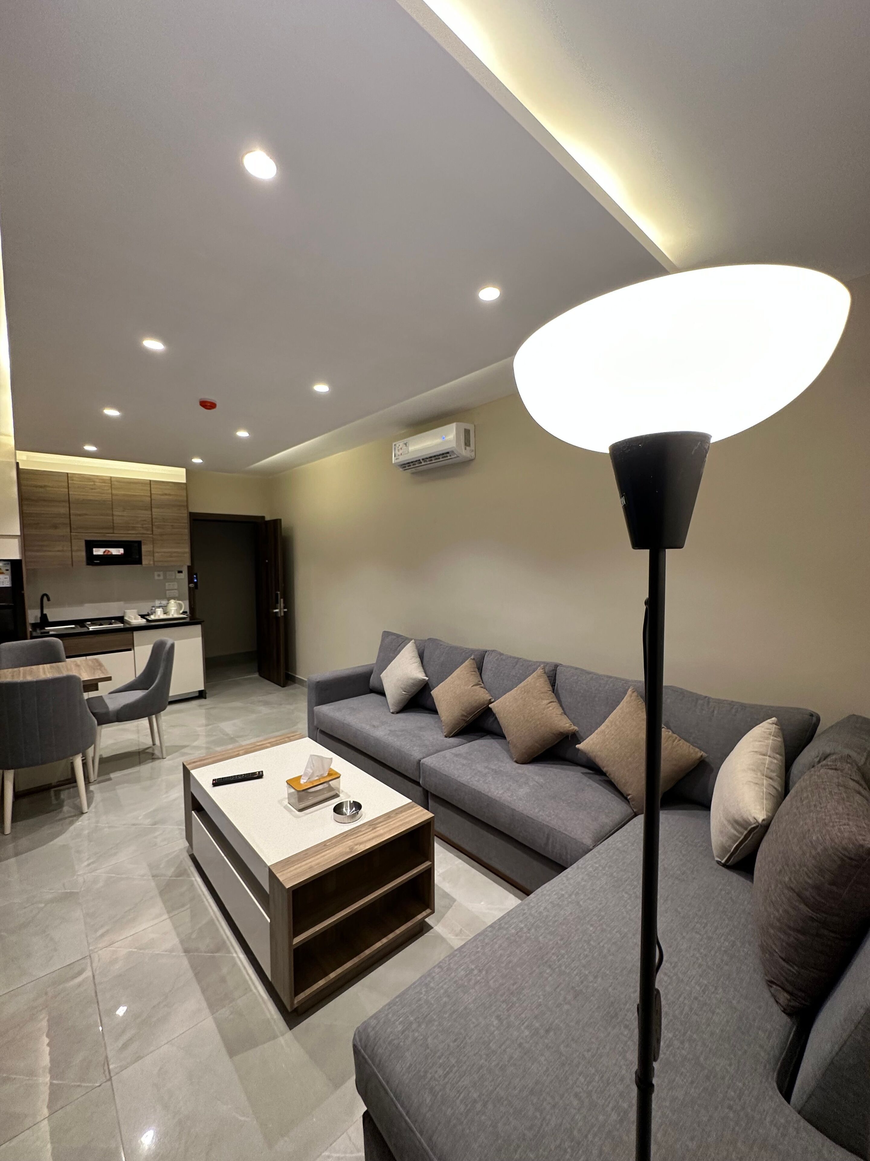 A modern living room with a grey sofa, a coffee table, and a floor lamp.