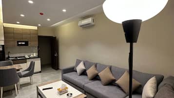 A modern living room with a grey sofa, a coffee table, and a floor lamp.