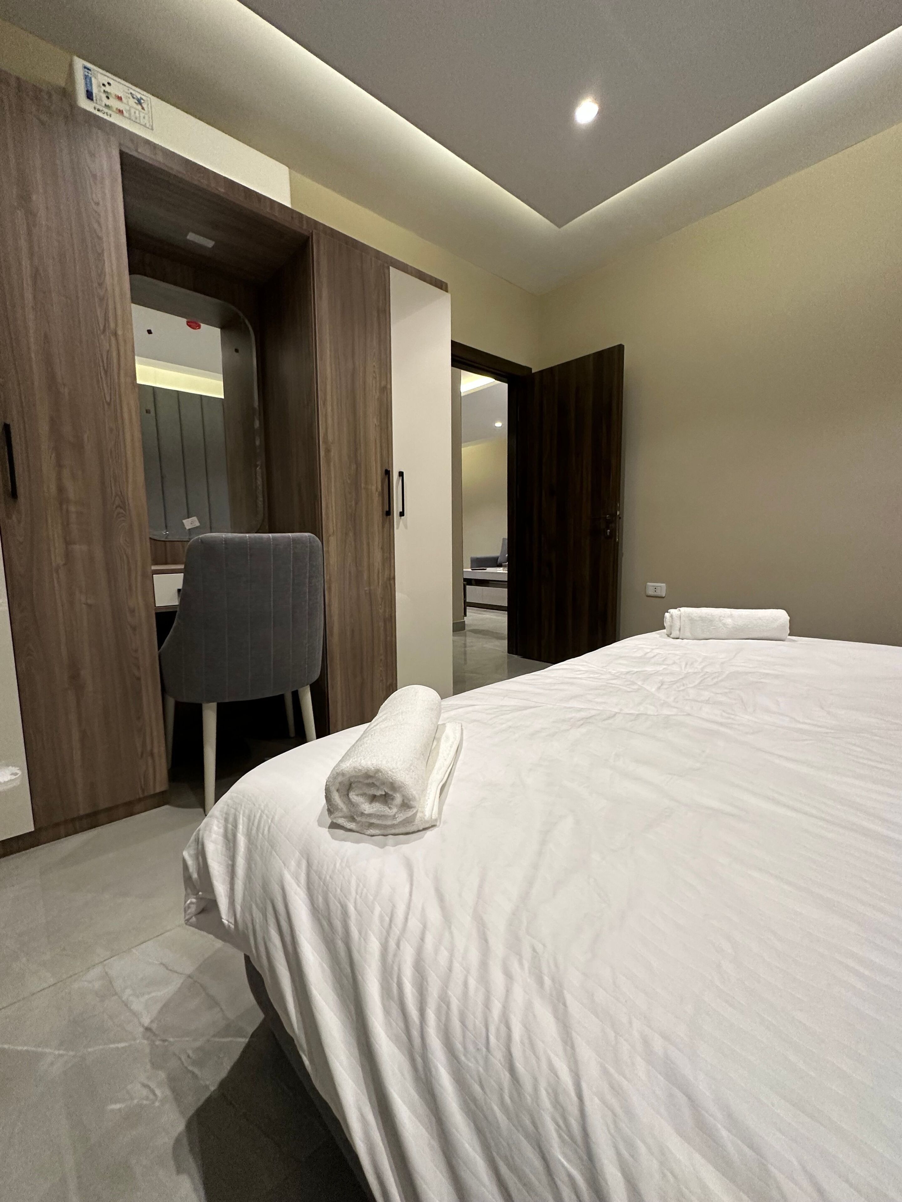 A hotel room with a bed, a desk, and a chair.