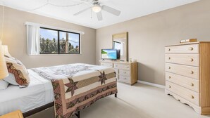 A bedroom with a bed, dresser, television, and a ceiling fan. - Adorable 2 Bedroom Condo - Pool & Prime Location (Fort Myers)