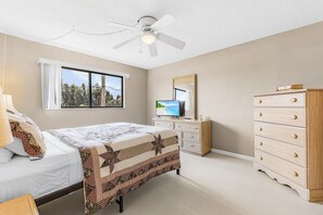 A bedroom with a bed, dresser, television, and a ceiling fan. - Adorable 2 Bedroom Condo - Pool & Prime Location (Fort Myers)