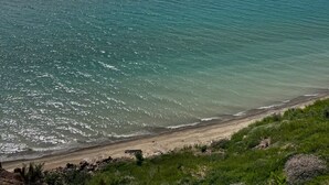 Un paisaje costero con playa, océano y cielo despejado.