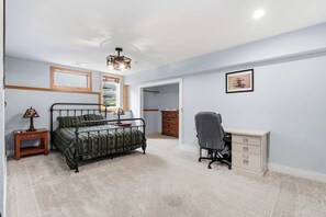 A bedroom with a bed, a desk, a chair, a dresser, and a window. - Rangeley Lakefront 3BR | Private Dock, Dogs OK (Rangeley)