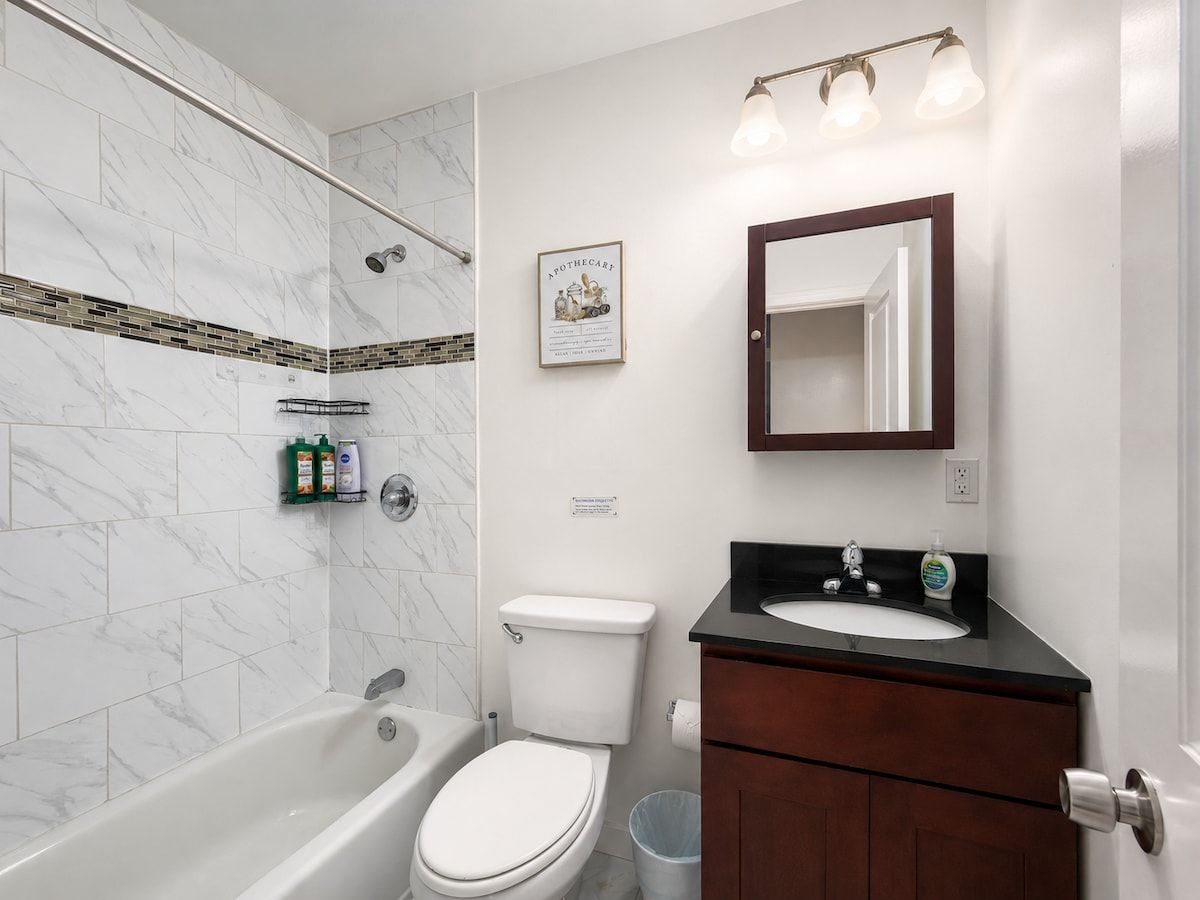 A bathroom with a bathtub, toilet, and sink.