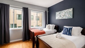 A hotel room with two beds, a large window, a dark wall, and a painting. - The Camac Hideaway - 2BR near Convention Center (Philadelphia)