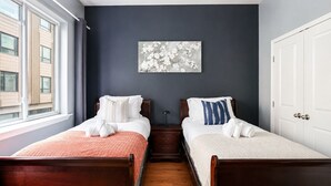 A hotel room with two wooden beds, a dark wall, a window, and a painting. - The Camac Hideaway - 2BR near Convention Center (Philadelphia)