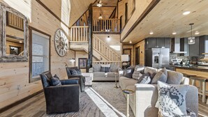 A spacious living area with a staircase, a kitchen, and a dining area. - The Overlook at Settlers Ridge (Sevierville)