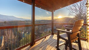 A wooden deck with a view of mountains and a sunset. - The Overlook at Settlers Ridge (Sevierville)