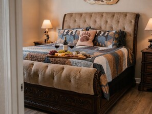 Ein Schlafzimmer mit einem großen Bett, einem Nachttisch, einer Lampe und einem dekorativen Wandbild.