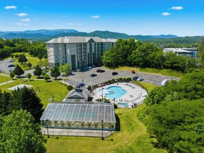 Hotel com piscina, área externa coberta e vista para montanhas.